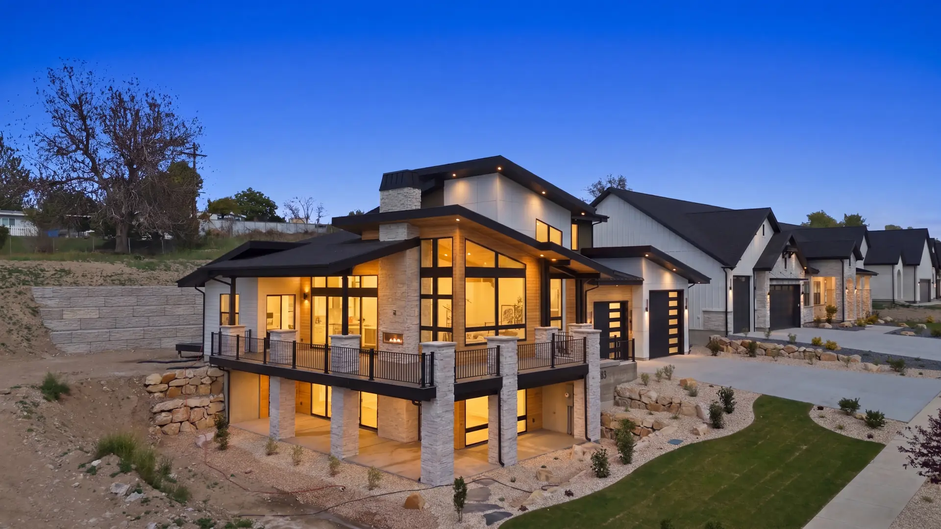 A completed Goldcrest home with expansive windows, illuminated at dusk